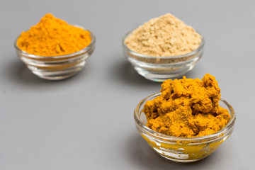 Herbal therapy concept. Spice set: ginger and turmeric powder, turmeric paste on light background. top view.