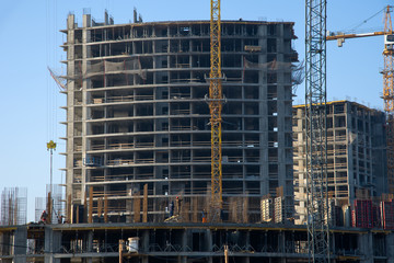 Reinforced formwork concrete for the during construction foundation. Building and structures using structural concrete. Tower crane lifts the block for building skeleton under construction