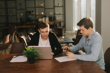 Business team young men talking strategy with laptop in modern office. Concept of teamwork young business people.