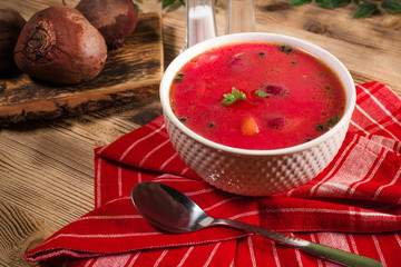 Red borscht soup in bowl.
