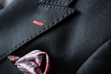 Handkerchief in a black suit pocket. Beautifully clothed pubs in a robe pocket.Black suit with a shirt pocket with a red apron and a beautiful pattern.