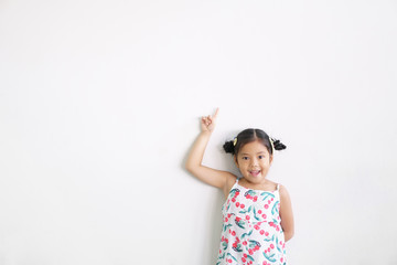 Asian child cute or kid girl thinking with finger point on top for new idea and imagination or creativity education with smiling happy at nursery preschool on white wall background and space isolated