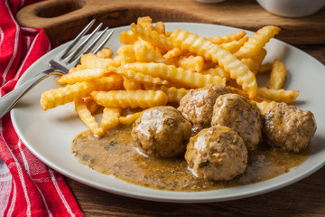 Meatballs with french fries in dill sauce.
