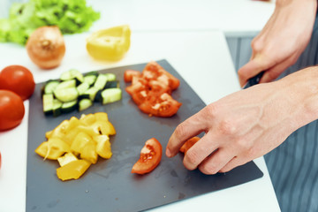 Obraz na płótnie Canvas woman cutting vegetables in kitchen