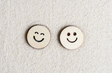 Two funny happy wooden smile face on the sand at the beach. Concept. Flat lay. Aerial view