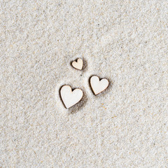 three wooden valentines hearts on the sand at the beach. Concept