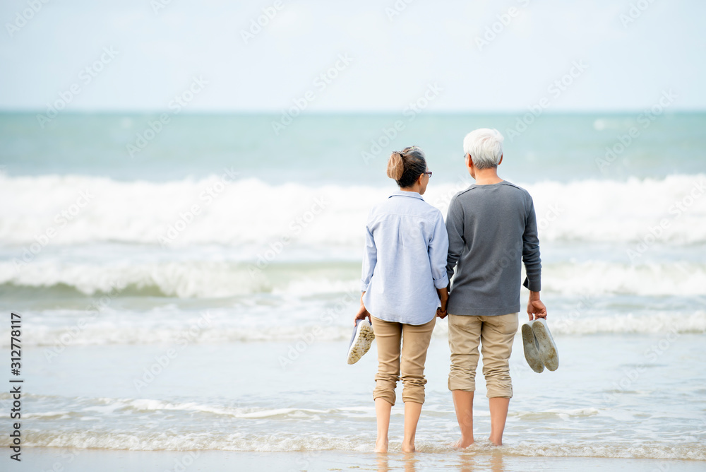 Wall mural Relax  asian senior couple  on beach  with  blue  sky  background