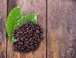 coffee beans with leaf on table wood