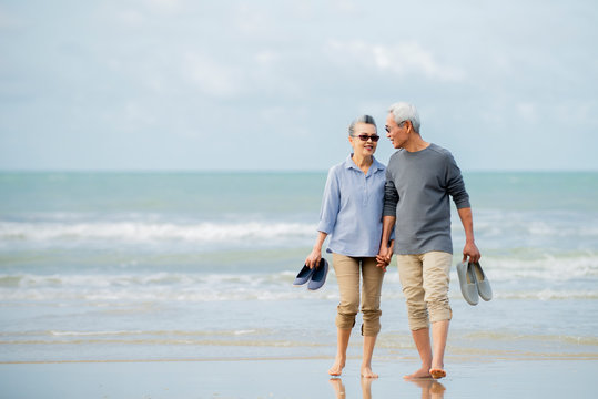 Relax  asian senior couple  on beach  with  blue  sky  background