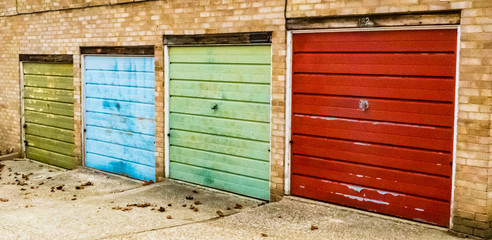 Row of small garages with different coloured doors, Bracknell England