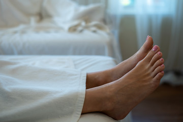 Woman foot on the massage bed. Sleeping rest relaxation in spa room with copy space