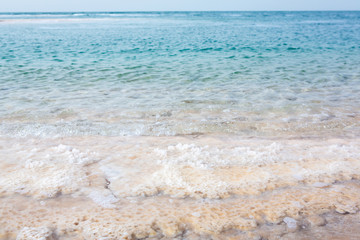 View of Dead Sea coastline at sunset time in Jordan. Salt crystals at sunset. Dead sea landscape with minehral structures.