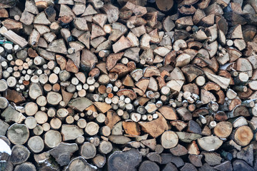 Chipped firewood for winter fire stacked on top of each other close-up, horizontal frame, background cover