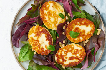 Cyprus fried halloumi with salad mix, beet tops. Lchf, pegan, fodmap, paleo, scd, keto, ketogenic diet. Balanced food, clean eating recipe. Top view, white background, close up