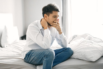 young man sitting on sofa and talking on cell phone