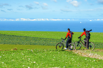 Obraz premium Two mountain bikers facing the English cliffs