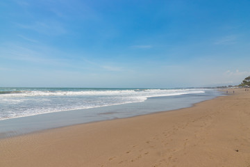Fototapeta na wymiar Seminyak beach. Wide sand beach with big waves, good for surfing; Bali island, Indonesia
