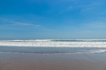 Fototapeta na wymiar Seminyak beach. Wide sand beach with big waves, good for surfing; Bali island, Indonesia