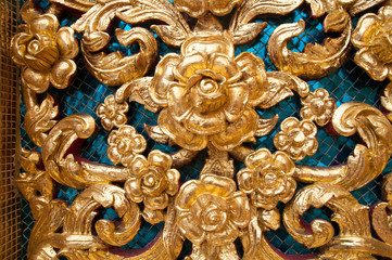 Traditional wood carving with ancient flower patterns decorating with gold mirror, Thailand