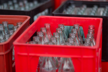 Red and black plastic crates with empty bottles
