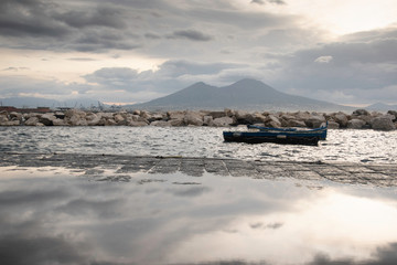 Decrepit old row boats in the harbor in Naples, Italy during the morning following a rain storm.