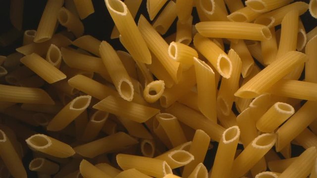 Penne Pasta is Falling in the Air on the Black Background Top Show at 1500 fps