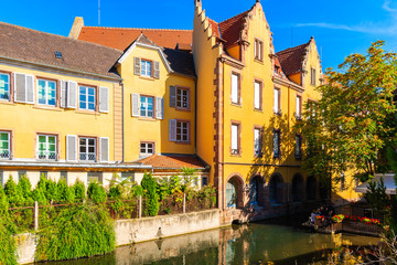 COLMAR, FRANCE - SEP 20, 2019: Yellow facade of beautiful house on La Lauch river canal in famous part of town named Little Venice, France.