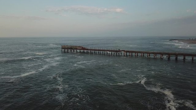 4K aerial drone video of Namibian Atlantic coastline, Swakopmund vintage buildings, town panorama, beach, old Jetty pier, landscape with ocean background of holiday resort at Namibia's west coast