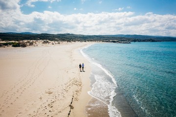 Aerial photo of couple walking on the beach in Sardegna Italy