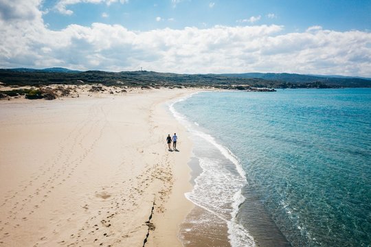 Aerial photo of couple walking on the beach in Sardegna Italy