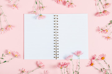 Beautiful flowers composition. Pink flowers and open notebook on pastel pink background. Valentines Day, Happy Women's Day, Mother's day. Flat lay, top view, copy space