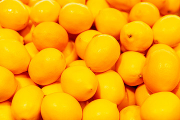 A lot of bright juicy lemons. Vitamins and health. Close-up. Background. Space for text.