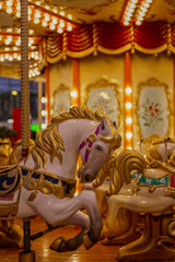 Fototapeta na wymiar Horses to sit in a street festive carousel. Mass festivities and fun. Close-up. Vertical.