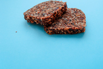 Sliced whole grain bread rye with seeds flax, sunflower, pumpkin and sesame.Healthy food, eco-friendly natural products. Fresh bread on a blue background.
