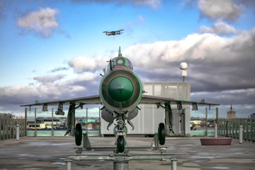 Photo of a military aircraft and a flying drone