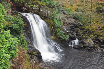 Fototapeta na wymiar River Arklet flows into Loch Lomond at Inversnaid waterfall. On the route of the West Highland Way long distance walking route next to Inversnaid Hotel.