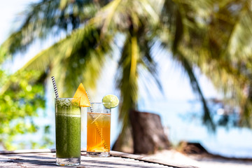 fresh green and orange cocktail on the paradise beach