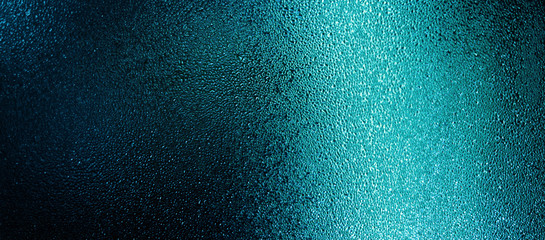 Blue color water drops on wet glass. Abstract texture background.