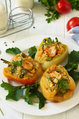 Vegetarian dish. Peppers stuffed with quinoa, shrimp  and vegetables on white wooden table.