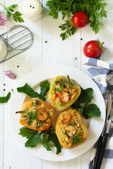 Vegetarian dish. Peppers stuffed with quinoa, shrimp  and vegetables on white wooden table. Top view flat lay background.
