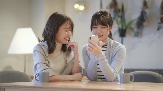 スマートフォンを視聴する二人の女性
