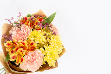 bouquet of pink ghoek, yellow chrysanthemum and Alstroemeria packed in paper isolated on a white background