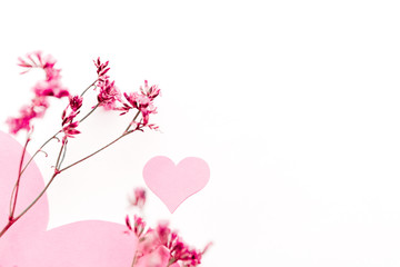 A large pink heart with a place for text decorated with small pink flowers on a white background