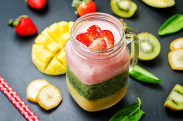 Mango Spinach strawberry kiwi banana smoothie with fresh fruit slices
