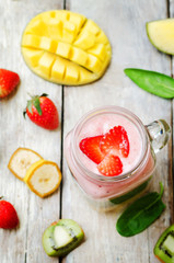Mango Spinach strawberry kiwi banana smoothie with fresh fruit slices