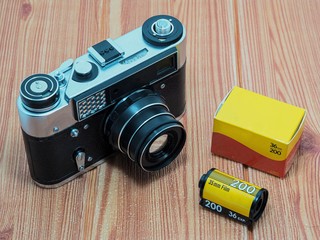 Vintage camera and roll film with on wooden background.