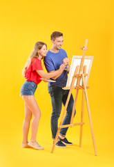 Fototapeta na wymiar Couple of young artists on color background