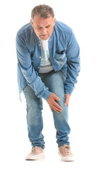 Obraz premium Mature man suffering from pain in knee on white background