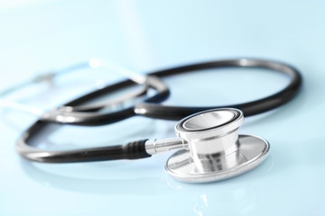 Modern stethoscope on white table, closeup