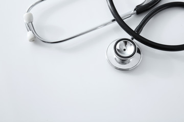 Modern stethoscope on white table